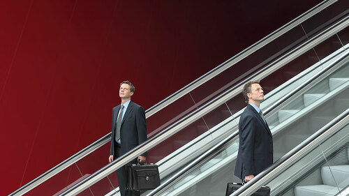 Anzugtraeger-auf.Rollreppe-72500615-FO-visivasnc