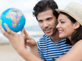 Paar-zeigt-auf-Globus-65859323-FO-contrastwerkstatt