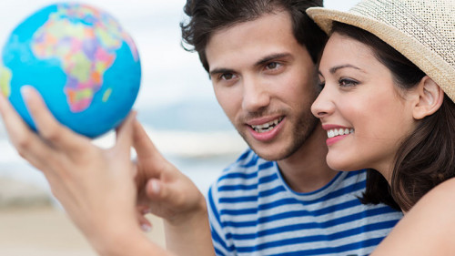 Paar-zeigt-auf-Globus-65859323-FO-contrastwerkstatt