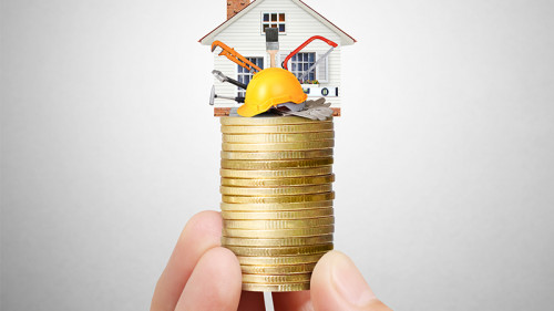 Haus-Muenzstapel-in-Fingerspitzen-67435235-FO-denphumi