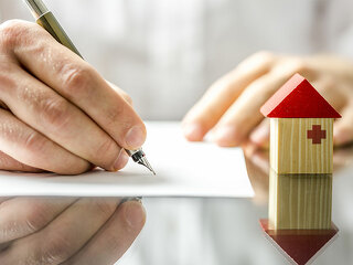 Hand-unterschreibt-Vertrag-Haeuschen-60245643-FO-Gajus