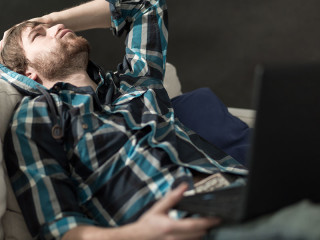 mann-depressiv-auf-couch-mit-laptop-86282376-FO-Photographee-eu