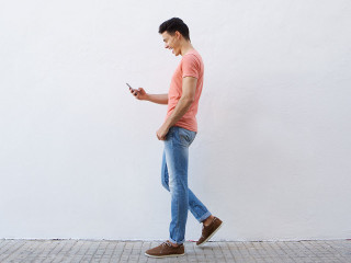 mann-geht-blick-auf-handy-89788690-FO-mimagephotos