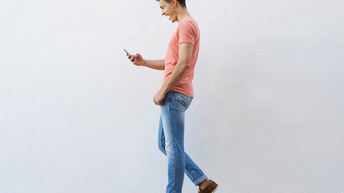 mann-geht-blick-auf-handy-89788690-FO-mimagephotos