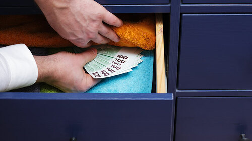 mann-legt-geld-in-schublade-98233878-FO-Victor-Koldunov