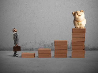 mann-vor-stufen-zum-sparschwein-75382085-FO-alphaspirit