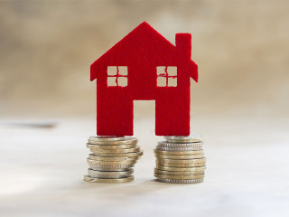 Rotes-Haus-auf-Muenzstapeln-89249649-FO-aytuncoylum