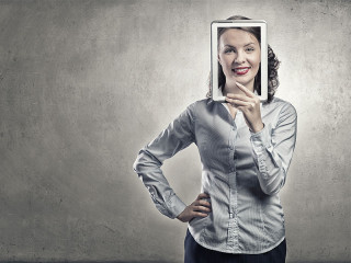 Frau-grinst-durch-Tablet-101086126-FO-Sergey-Nivens