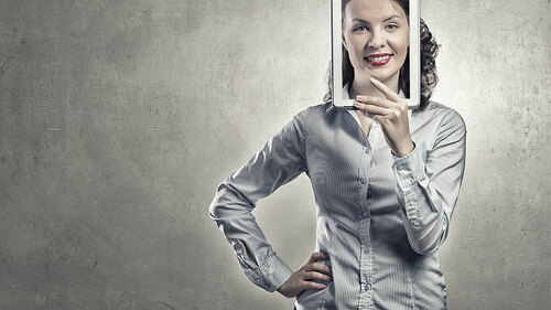 Frau-grinst-durch-Tablet-101086126-FO-Sergey-Nivens