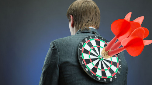 anzugtraager-dartscheibe-pfeile-im-ruecken-63789936-fo-nomad-soul