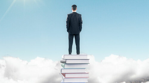 anzugtraeger-auf-buecherstapel-99827408-fo-peshkov