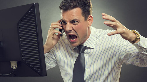 Anzugtraeger-schreit-in-Telefon-vor-Bildschirm-66116445-FO-Photosebia