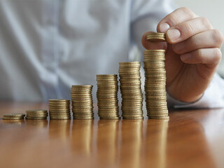 Mann-stapelt-Muenzen-78371559-FO-tunedin