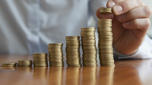 Mann-stapelt-Muenzen-78371559-FO-tunedin