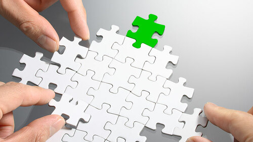 Haende-bauen-Pfeil-aus-Puzzleteilen-59730628-FO-tadamichi