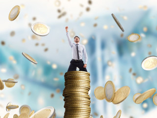 Anzugtraeger-auf-Muenzstapel-Geldregen-149649989-FO-alphaspirit