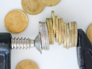 Muenzen-in-Schraubstock-114367884-FO-adrian-ilie825