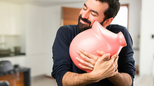 Mann-umarmt-Sparschwein-171749371-FO-luismolinero