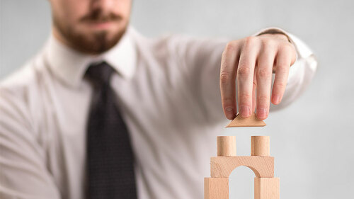 Anzugtraeger-baut-Turm-179314472-FO-ra2-studio