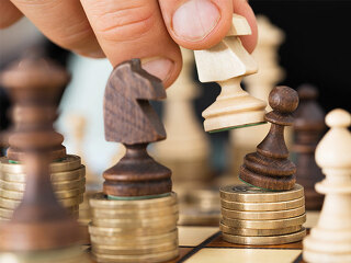 Schachfiguren-auf-Muenzstapeln-73517880-FO-Andrey-Popov