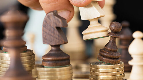 Schachfiguren-auf-Muenzstapeln-73517880-FO-Andrey-Popov
