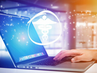 Laptop-Hand-Aeskulapstab-159187337-FO-Production-Perig