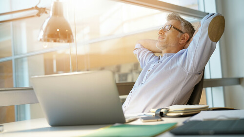 Businessman in office relaxing in chair
