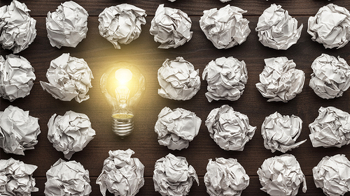 Gluehbirne-zwischen-zerknuelltem-Papier-80363721-FO-Ruslan-Grumble