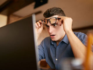 Mann-Brille-Laptop-ueberrascht-191749520-FO-artiemedvedev