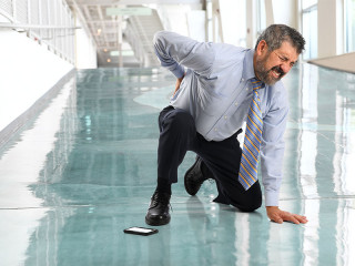 Anzugtraeger-kniet-haelt-sich-Ruecken-143082457-FO-Gino-Santa-Maria