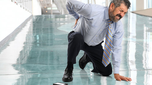 Anzugtraeger-kniet-haelt-sich-Ruecken-143082457-FO-Gino-Santa-Maria