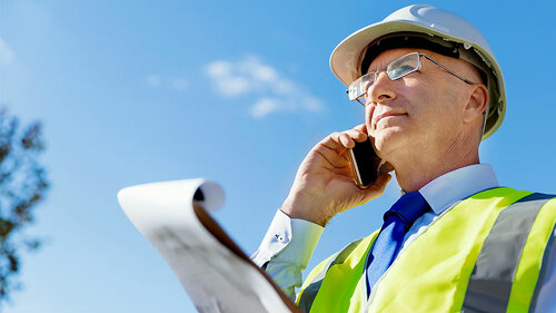 Mann-Schutzhelm-Mobiltelefon-172381891-FO-Sergey-Nivens