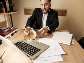 Anzugtraeger-verschuettet-Kaffe-auf-Laptop-192338305-FO-master1305