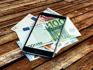 Geldscheine-in-und-unter-Smartphone-191386795-FO-alexkorp09