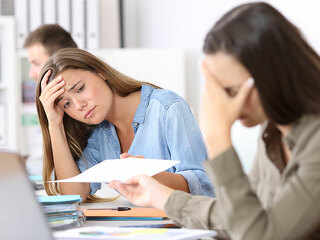 Anzugtraegerin-verzweifelt-Papier-166448613-FO-Antonioguillem