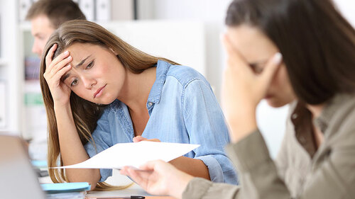 Anzugtraegerin-verzweifelt-Papier-166448613-FO-Antonioguillem