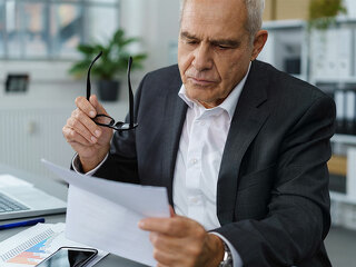 Anzugtraeger-liest-Brief-127365914-FO-contrastwerkstatt