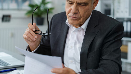 Anzugtraeger-liest-Brief-127365914-FO-contrastwerkstatt