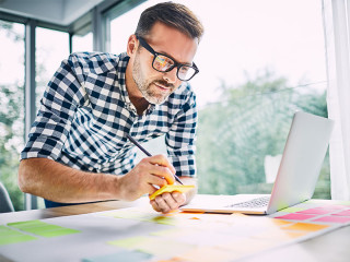 Mann-Homeoffice-Laptop-Post-its-212866895-FO-baranq