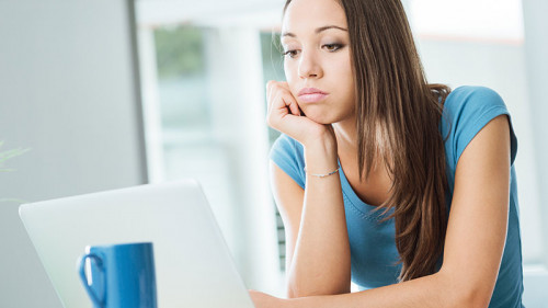 Frau-Laptop-geistloser-Gesichtsausdruck-87259779-FO-StockPhotoPro