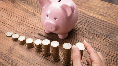 Hand-Sparschwein-Muenzstapel-144420589-FO-Andrey-Popov