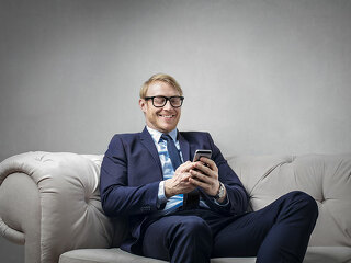 mann-lachend-auf-couch-handy-140714203-FO-olly