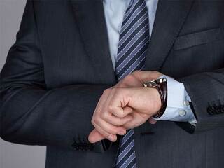 Anzugtraeger-sieht-auf-Armbanduhr-98585742-FO-morganka