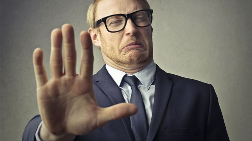 Anzugtraeger-abwehrende-Geste-139608636-FO-olly