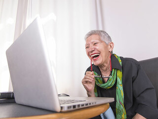 Lachende-Seniorin-vor-Laptop-188302619-FO-Teodor-Lazarev
