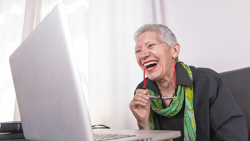 Lachende-Seniorin-vor-Laptop-188302619-FO-Teodor-Lazarev