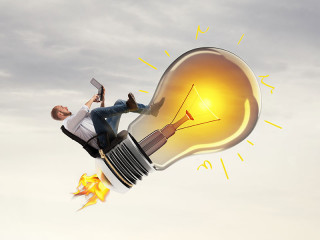 Anzugtraeger-reitet-auf-Gluehbirne-188328355-FO-alphaspirit