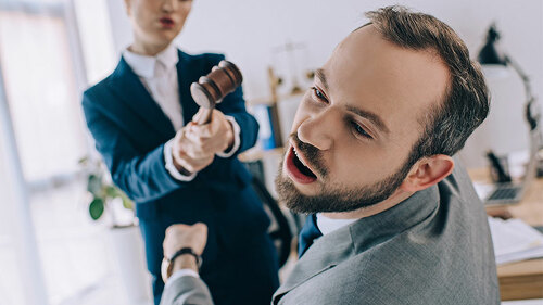 Anzugtraegerin-schlaegt-Anzugtraeger-mit-Hammer-199276347-FO-LIGHTFIELD-STUDIOS