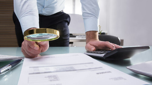 Anzugtraeger-Papier-Lupe-Taschenrechner-199510789-FO-Andrey-Popov