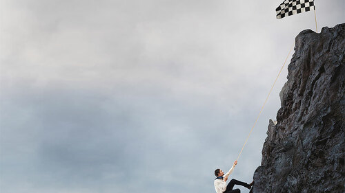 Anzugtraeger-erklettert-Berg-143233337-FO-alphaspirit